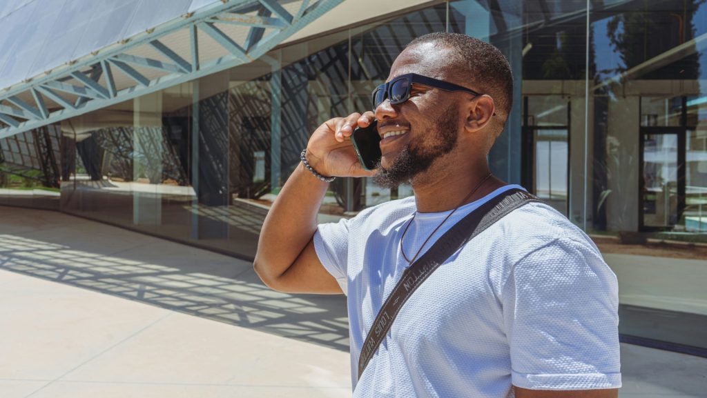 a man talking on a cell phone while wearing sunglasses